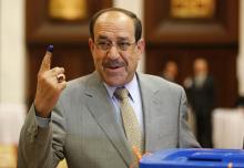 Iraq's Prime Minister Nuri al-Maliki shows his ink marked finger as he votes during parliamentary election in Baghdad
