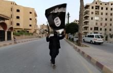 A member loyal to the Islamic State in Iraq and the Levant (ISIL) waves an ISIL flag in Raqqa June 29, 2014. REUTERS/Stringer