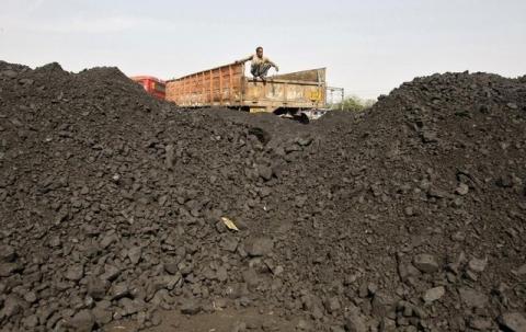 A worker sits on a truck as he waits for the loading of coal at a railway coal yard on the outskirts of the western Indian city of Ahmedabad, November 25, 2013. PHOTO BY REUTERS/Amit Dave