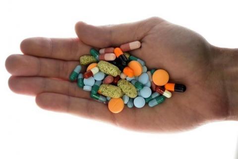 A person holds pharmaceutical tablets and capsules in this picture illustration taken in Ljubljana, September 18, 2013. PHOTO BY REUTERS/Srdjan Zivulovic