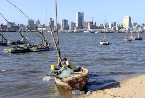 A fisherman cleans his boat beneath Maputo's skyline, August 15, 2015. PHOTO BY REUTERS/Grant Lee Neuenburg