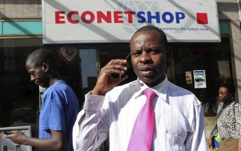 A Zimbabwean man speaks on his phone outside a branch of mobile service provider Econet Wireless in central Harare, June 6, 2014. PHOTO BY REUTERS/Philimon Bulawayo