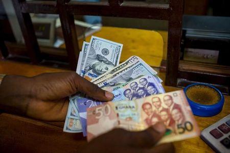 A man trades U.S. dollars for Ghanaian cedis at a currency exchange office in Accra, Ghana, June 15, 2015. PHOTO BY REUTERS/Francis Kokoroko