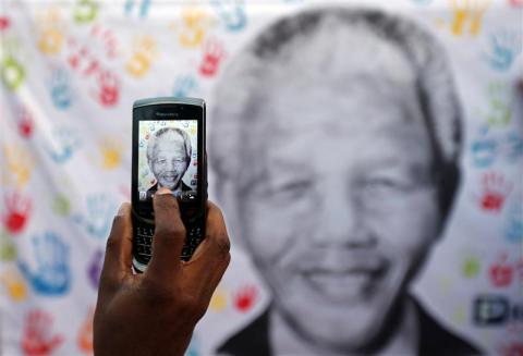 A well wisher takes a picture of Nelson Mandela