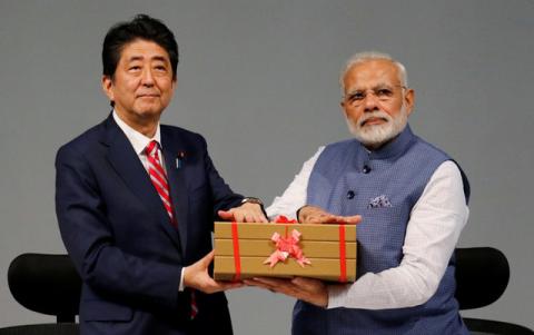 Japanese Prime Minister Shinzo Abe (L) and his Indian counterpart Narendra Modi hold a replica of a brick during the India-Japan Annual Summit, in Gandhinagar, India, September 14, 2017. PHOTO BY REUTERS/Amit Dave