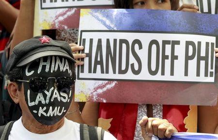 An activist wears a black mask with a message reading "China Get Out!" as they protest against Beijing's activities in the South China Sea outside the Chinese consulate in Makati city, metro Manila, July 7, 2015. PHOTO BY REUTERS/Romeo Ranoco
