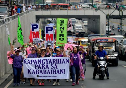 Women's rights activists display streamer that reads "Women's Empowerment" while marching along a busy street during a celebration of the Women's International Day in Quiapo city, metro Manila, Philippines. PHOTO BY REUTERS/Romeo Ranoco
