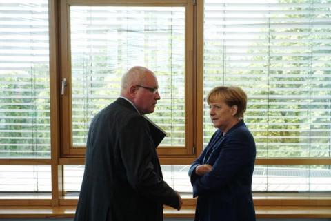 German Chancellor and leader of Christian Democratic Union (CDU) Angela Merkel (R) listens to party's faction leader Volker Kauder during a meeting of party leaders in Berlin