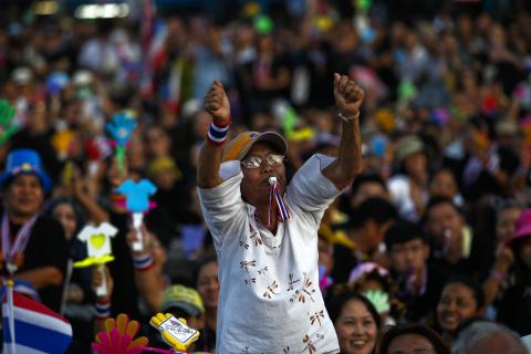 An anti-government protester blows her whistle during a rally at Democracy Monument in Bangkok