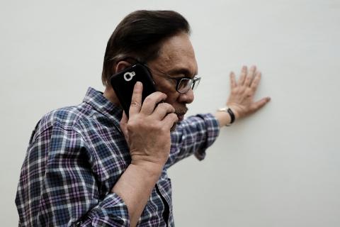 Malaysian politician Anwar Ibrahim takes a phone call during during an interview with Reuters at his house in Kuala Lumpur, Malaysia, May 17, 2018. PHOTO BY REUTERS/Stringer