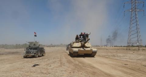 Iraqi security forces ride on a tank during a military operation to fight against Islamic State militants in the town of Hit in Anbar province, April 2, 2016. PHOTO BY REUTERS/Stringer