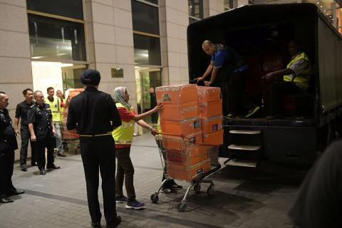A Malaysian police officer pushes a trolley during a raid of three apartments in a condominum owned by former Malaysian prime minister Najib Razak’s family, in Kuala Lumpur, May 17, 2018, in this photo taken by The Straits Times. PHOTO BY REUTERS/Ariffin Jamar/The Straits Times 