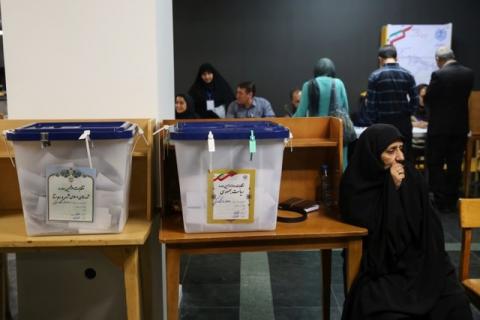 Electoral employees sits next to ballot boxes before closing vote for the presidential election in a polling station in Tehran, Iran, May 19, 2017. PHOTO BY REUTERS/TIMA