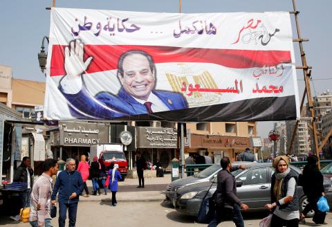 People walk by a poster of Egyptian President Abdel Fattah al-Sisi for the upcoming presidential election, in Cairo, Egypt, March 1, 2018. PHOTO BY REUTERS/Amr Abdallah Dalsh