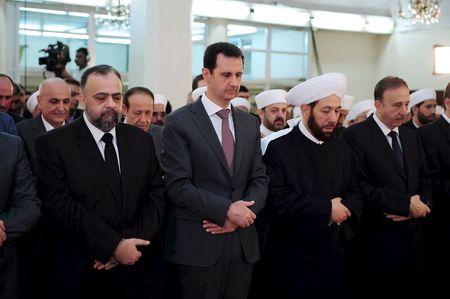 Syria's President Bashar al-Assad (2nd L) attends Eid al-Fitr prayers at al-Hamad mosque in Damascus, Syria, in this handout released by Syria's national news agency SANA, July 17, 2015. PHOTO BY REUTERS/SANA