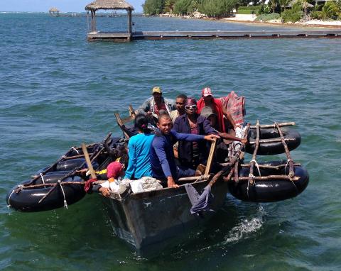A home-made aluminum boat carrying 16 Cuban migrants pulls up to a dock seeking what the migrants said was refuge from rough seas, in Grand Cayman island