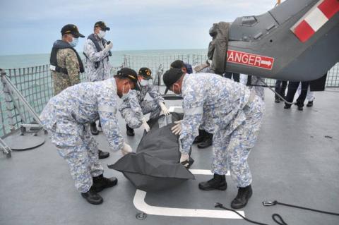 Royal Malaysian Navy personnel carry a body onto their ship during a search and rescue operation for survivors of the USS John McCain ship collision in Malaysian waters in this undated handout released August 22, 2017. PHOTO BY REUTERS/Royal Malaysian Navy