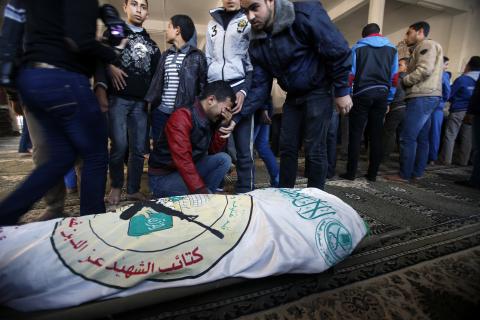 A man mourns next to the body of Hamas' armed wing member Tayseer Asmairi, who was shot dead by Israeli forces, during his funeral in Khan Younis in the southern Gaza Strip, December 24, 2014. PHOTO BY REUTERS/Suhaib Salem