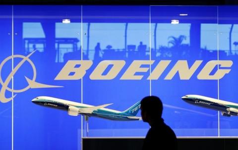 A man looks at a scale model of Boeing's 787 dreamliner at their booth at the Singapore Air Show in Singapore, February 19, 2008. PHOTO BY REUTERS/Vivek Prakash