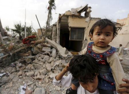 A boy carries his sister near the collapsed house of Yemen's late prime minister Faraj Bin Ghanim after it was hit by a Saudi-led air strike in Sanaa, July 2, 2015. PHOTO BY REUTERS/Khaled Abdullah