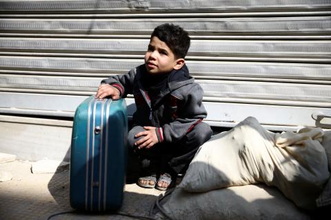 A boy holds a suitcase during evacuation from the besieged town of Douma, Eastern Ghouta, in Damascus, Syria, March 13, 2018. PHOTO BY REUTERS/Bassam Khabieh