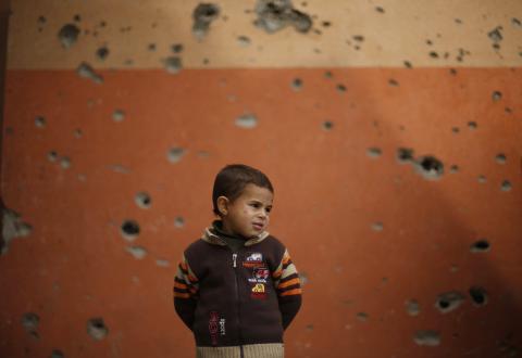 A Palestinian boy stands outside a mosque, that witnesses said was damaged by Israeli shelling during the most recent conflict between Israel and Hamas, on a winter day in Beit Hanoun town, northern Gaza Strip, November 25, 2014. PHOTO BY REUTERS/Suhaib Salem