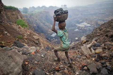A boy carries coal at an open cast coal field at Dhanbad district in the eastern Indian state of Jharkhand, September 20, 2012. PHOTO BY REUTERS/Ahmad Masood