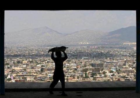 A boy carries bread on his head to sell on a hilltop overlooking Kabul, April 20, 2015. PHOTO BY REUTERS/Mohammad Ismail