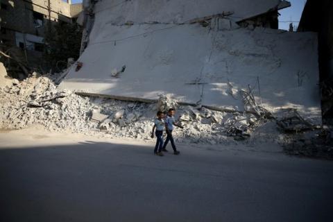 Boys walk near a damaged building on the first day of Eid al-Adha celebrations in the rebel held Douma neighbourhood of Damascus, Syria, September 12, 2016. PHOTO BY REUTERS/Bassam Khabieh