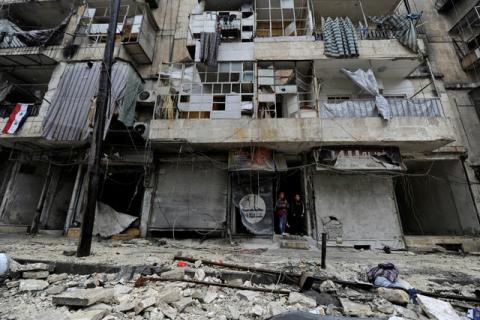 Boys stand amid the damage in the government-held al-Shaar neighborhood of Aleppo, during a media tour, Syria, December 13, 2016. PHOTO BY REUTERS/Omar Sanadiki