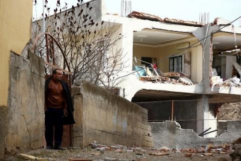 A man stands next to a building, damaged after a truck bomb attack on a nearby police station, in Cinar in the southeastern city of Diyarbakir, Turkey, January 14, 2016. PHOTO BY REUTERS/Sertac Kayar
