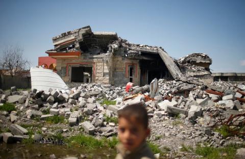 An Iraqi boy walks past a building destroyed during the fighting between Iraqi forces and Islamic states militants in Qayyara, Iraq, April 6, 2017. PHOTO BY REUTERS/Suhaib Salem