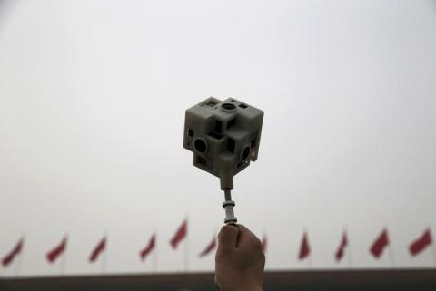 A reporter holds a 360 degree virtual reality camera in front of the Great Hall of the People before the opening session of the Chinese People's Political Consultative Conference (CPPCC), in Beijing, China, March 3, 2016. PHOTO BY REUTERS/Kim Kyung-hoon