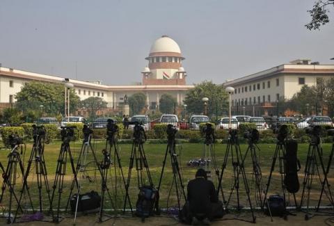 A television journalist sets his camera inside the premises of the Supreme Court in New Delhi, February 18, 2014. PHOTO BY REUTERS/Anindito Mukherjee