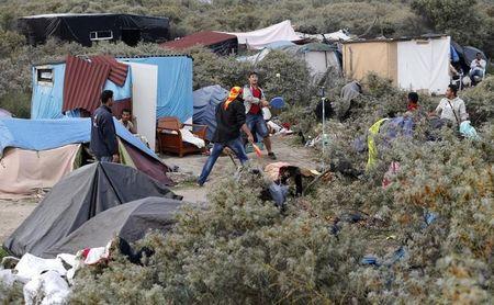 Migrants play paddle ball near tents in the makeshift camp called "The New Jungle" in Calais, France, August 19, 2015. PHOTO BY REUTERS/Regis Duvignau