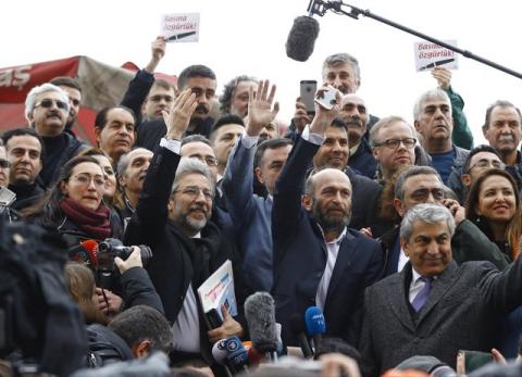 Can Dundar, editor-in-chief of Cumhuriyet, (centre L) and his Ankara bureau chief Erdem Gul greet their supporters as they arrive at the Justice Palace in Istanbul, Turkey, March 25, 2016. PHOTO BY REUTERS/Osman Orsal