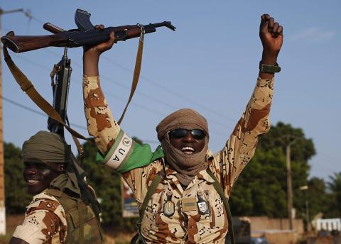 Chadian soldiers wave their guns as they drive in Bangui