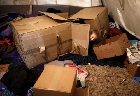 A Muslim Bosniak child plays amongst boxes in a camp in Sarajevo