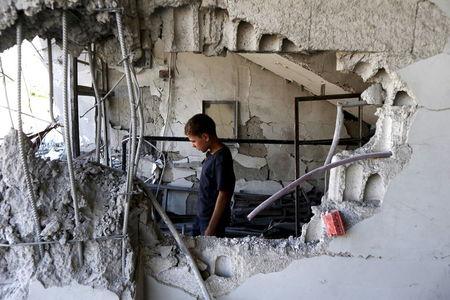 A child inspects a site hit by what activists said was an airstrike by forces loyal to Syria's President Bashar el-Asaad at Arbin town in Damascus countryside, Syria, July 21, 2015. PHOTO BY REUTERS/Bassam Khabieh