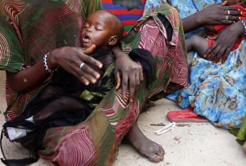 A woman holds her malnourished child in Sirlaabe IDP camp in Mogadishu