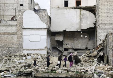 Children walk on the debris of a damaged building at al-Myassar neighborhood of Aleppo, February 16, 2015. PHOTO BY REUTERS/Hosam Katan