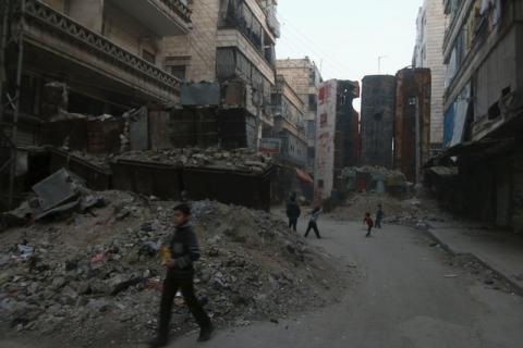 Children play near upright buses barricading a street, which serve as protection from snipers loyal to Syria's President Bashar al-Assad, in Aleppo's rebel-controlled Bustan al-Qasr neighbourhood, Syria, April 6, 2016. PHOTO BY REUTERS/Abdalrhman Ismail