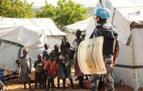 A U.N. peacekeeper stands guard near children displaced in recent fighting, during a visit by the United Nations Security Council, delegation to the UN House in Jebel, near South Sudan's capital Juba, September 3, 2016. PHOTO BY REUTERS/Jok Solomun
