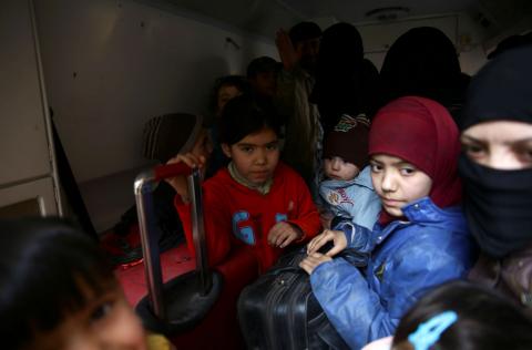 Children hold suitcases during evacuation from the besieged town of Douma, Eastern Ghouta, in Damascus, Syria, March 13. PHOTO BY REUTERS/Bassam Khabieh