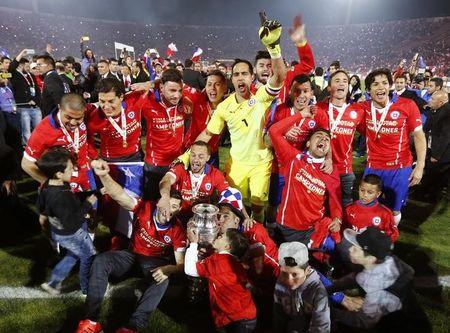 Chile celebrates with the trophy after defeating Argentina to win the Copa America 2015 final soccer match at the National Stadium in Santiago, Chile, July 4, 2015. PHOTO BY REUTERS/Marcos Brindicci