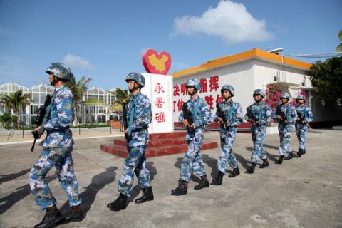 Soldiers of China's People's Liberation Army (PLA) Navy patrol at Fiery Cross Reef, in the Spratly Islands, known in China as the Nansha Islands, February 9, 2016. PHOTO BY REUTERS/Stringer