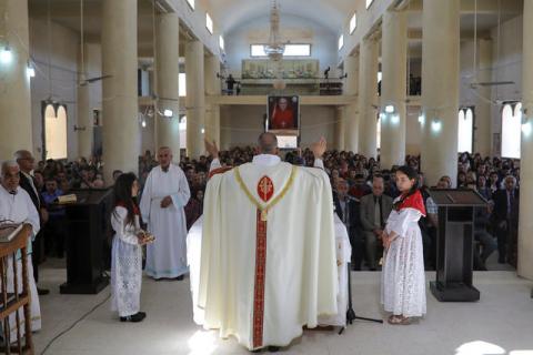 A priest leads the Easter Mass in Mar Gewargis (St George) Chaldean Catholic church, which was damaged by Islamic State militants, in the town of Tel Esqof, Iraq, April 16, 2017. PHOTO BY REUTERS/Marko Djurica
