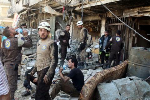 Civil defense members rest amid rubble of damaged buildings after an airstrike on the rebel-held Tariq al-Bab neighborhood of Aleppo, Syria. PHOTO BY REUTERS/Abdalrhman Ismail