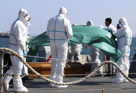 Coffins containing bodies of migrants who died are carried off a navy ship at the Sicilian harbour of Augusta