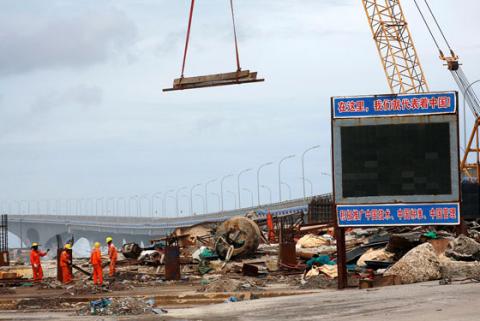 Construction workers work at a site as the China-funded Sinamale bridge is seen in Male, Maldives, September 18, 2018. PHOTO BY REUTERS/Ashwa Faheem